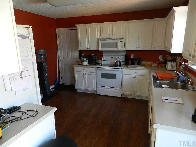 174 Roping Horn Way Willow Spring, NC 27592 - Photo 6 of 15 a kitchen with stainless steel appliances a stove a sink a refrigerator white cabinets and a window