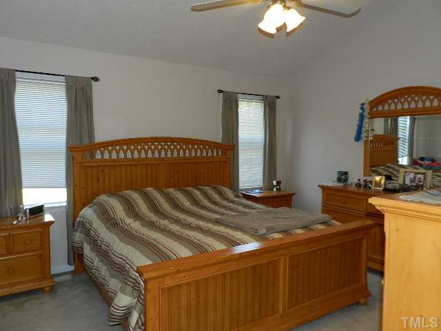 174 Roping Horn Way Willow Spring, NC 27592 - Photo 7 of 15 a bedroom with a bed and a chandelier