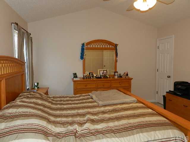 174 Roping Horn Way Willow Spring, NC 27592 - Photo 8 of 15 a bedroom with a bed and a lamp