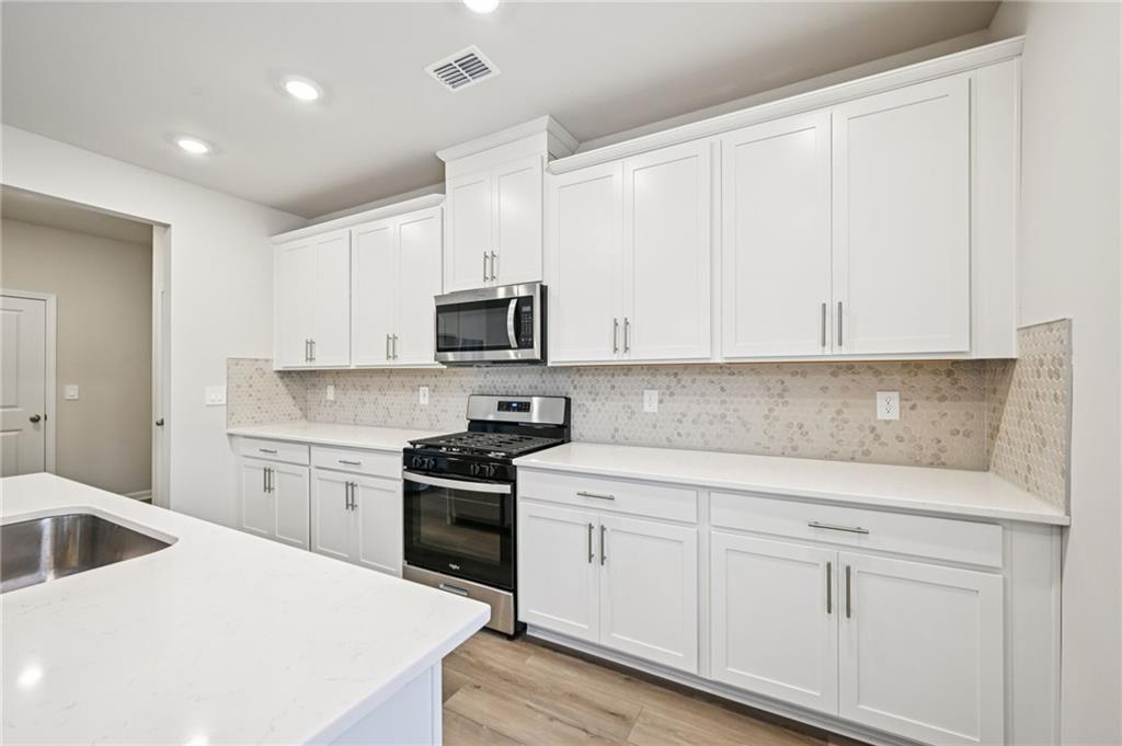 1408 High Fls Lane Grayson, GA 30017 - Photo 17 of 48 a kitchen with white cabinets appliances and sink