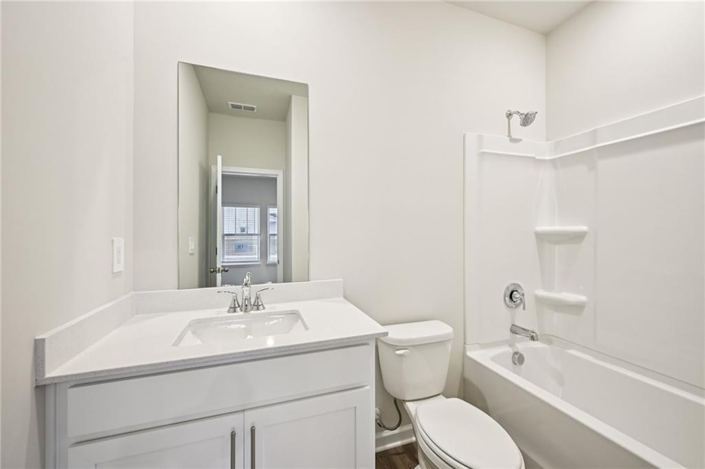 1408 High Fls Lane Grayson, GA 30017 - Photo 21 of 48 a bathroom with a granite countertop toilet a sink and a bathtub