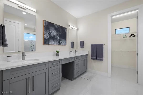 a bathroom with a double vanity sink mirror and bathtub