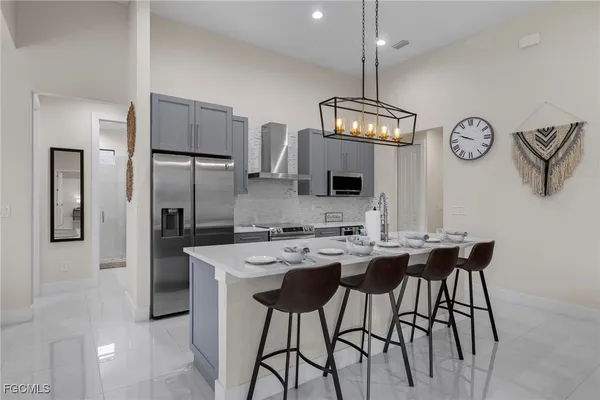 a kitchen with stainless steel appliances a kitchen island a stove a table and chairs in it