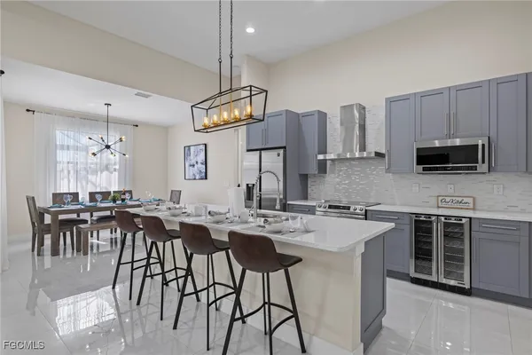 a kitchen with stainless steel appliances granite countertop a stove top oven a sink a dining table and chairs