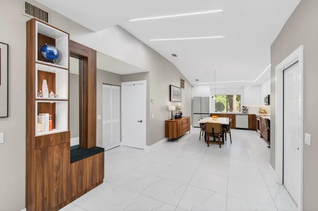 a room with furniture a air conditioner vent and a window