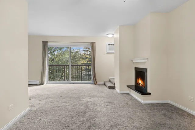 a view of an empty room with a window and fireplace