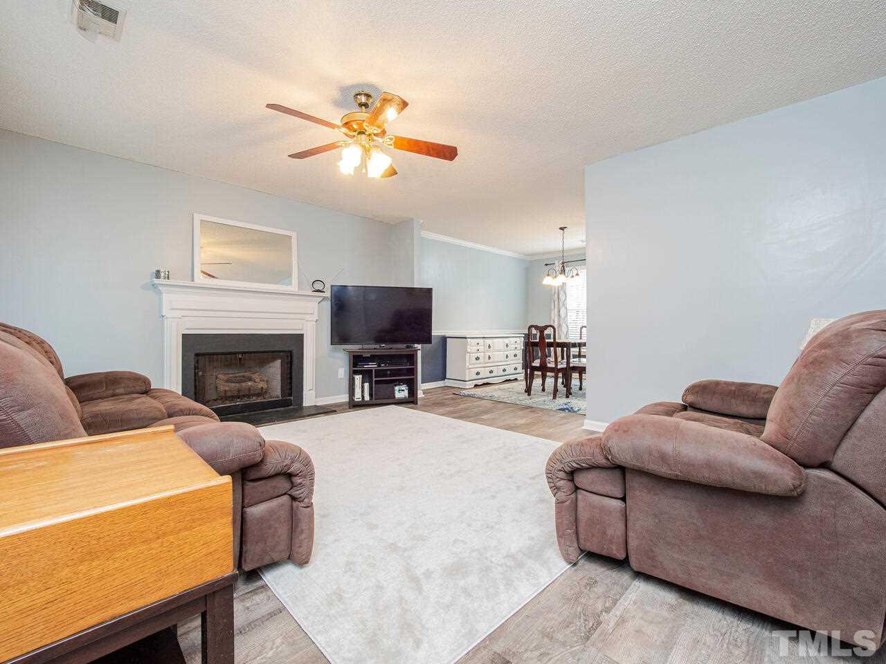 3540 Tunas Street Raleigh, NC 27616 - Photo 14 of 24 a living room with furniture a fireplace and a flat screen tv