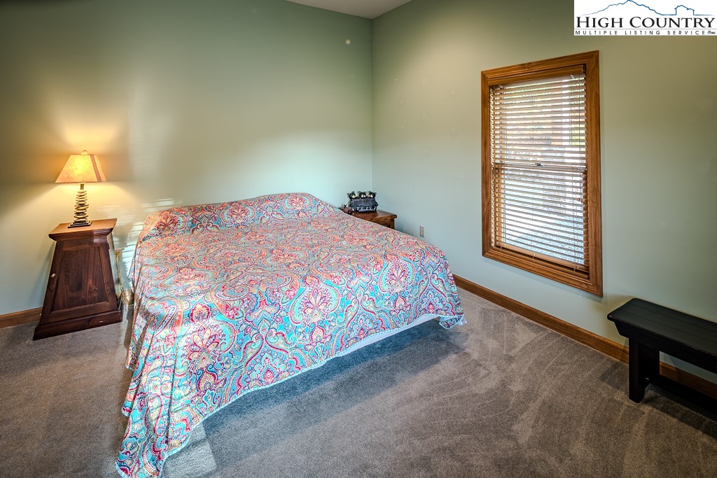 196 Hanley Lane Boone, NC 28607 - Photo 16 of 27 a bedroom with a bed and a lamp
