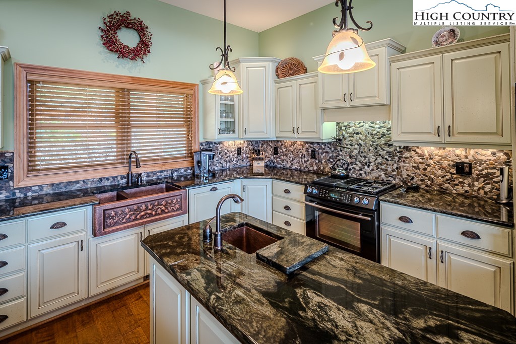 196 Hanley Lane Boone, NC 28607 - Photo 10 of 27 a kitchen with granite countertop a sink a stove and cabinets