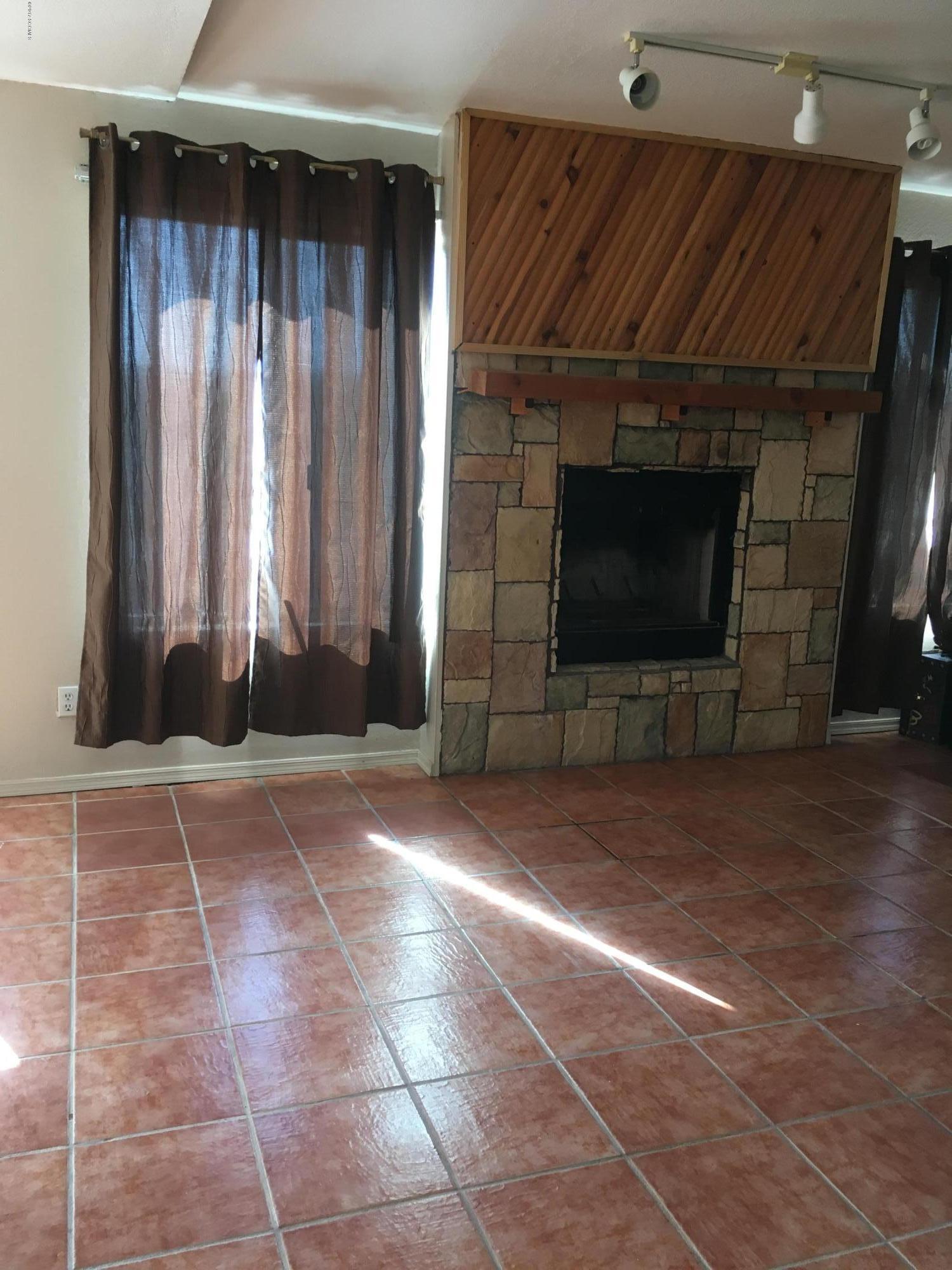 211 Toltec Court Rio Rico, AZ 85648 - Photo 2 of 6 a living room with a fireplace furniture a ceiling fan and a window
