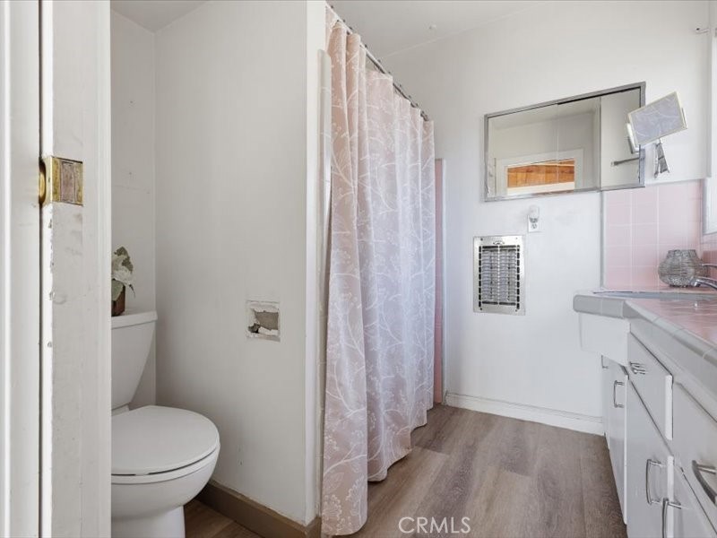 19876 Lodema Road Apple Valley, CA 92307 - Photo 23 of 40 a bathroom with a granite countertop toilet a sink and a mirror