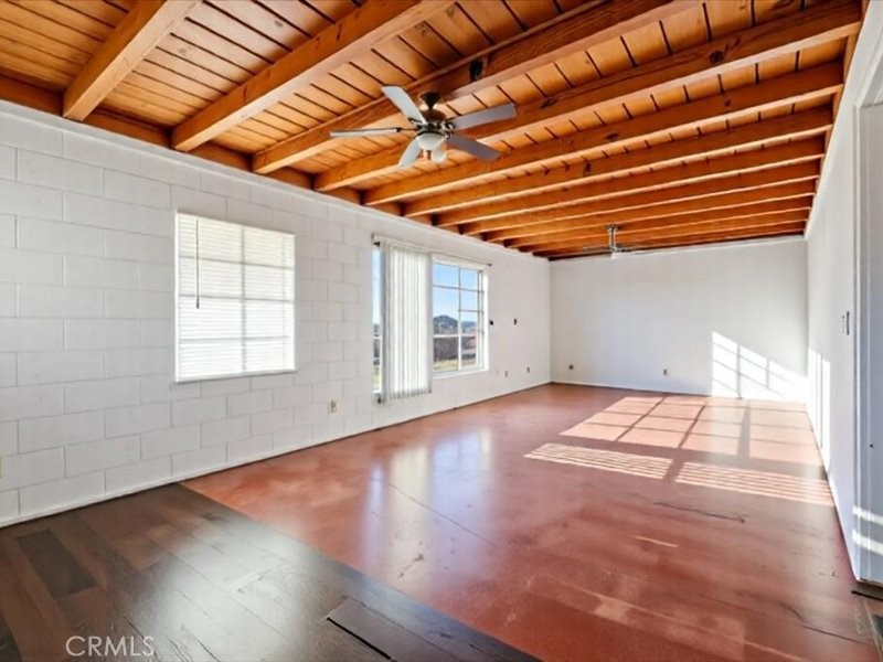 19876 Lodema Road Apple Valley, CA 92307 - Photo 5 of 40 a view of an empty room with wooden floor and a window