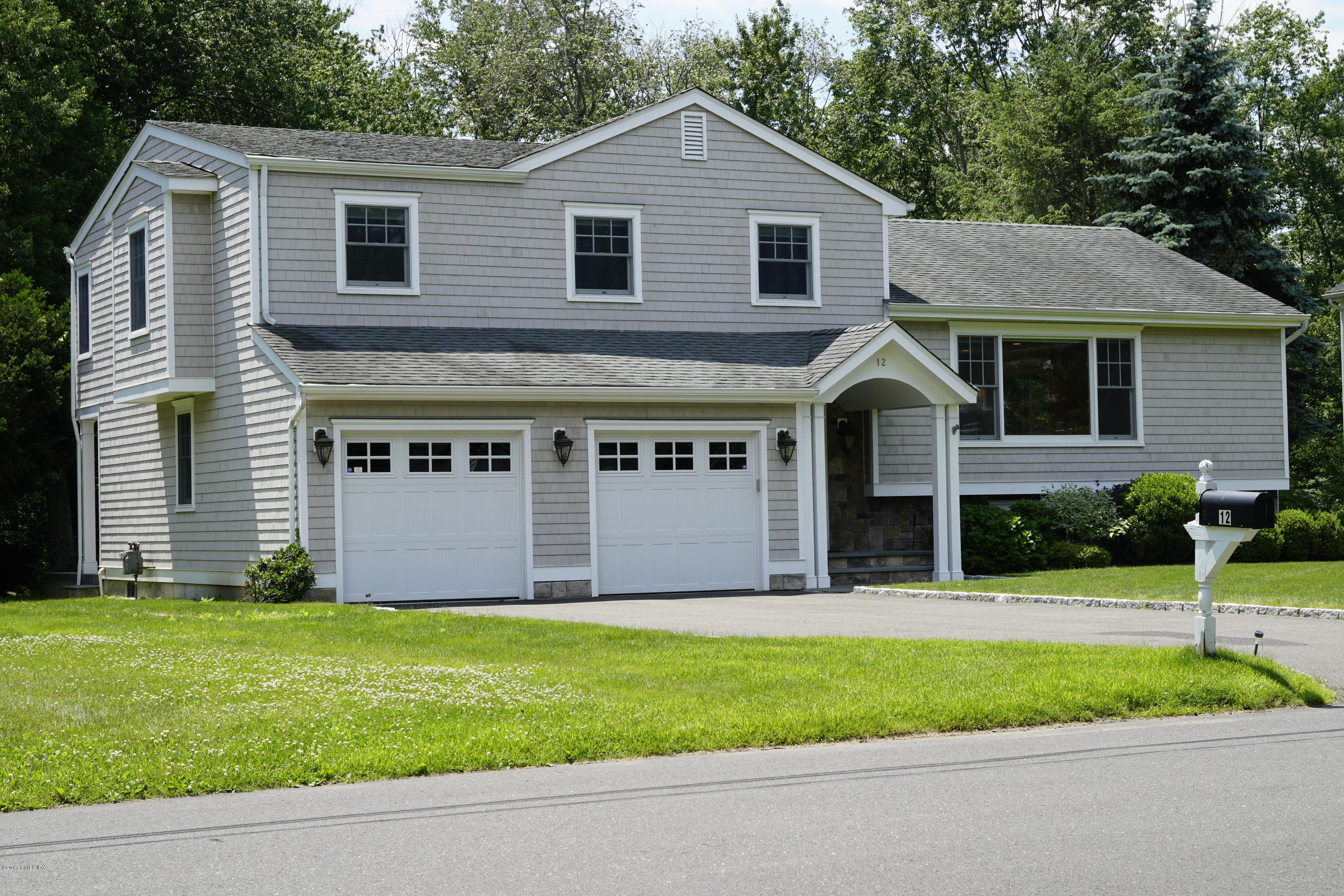 12 Birdsong Place Riverside, CT 06878 - Photo 1 of 30 a front view of a house with a yard and garage