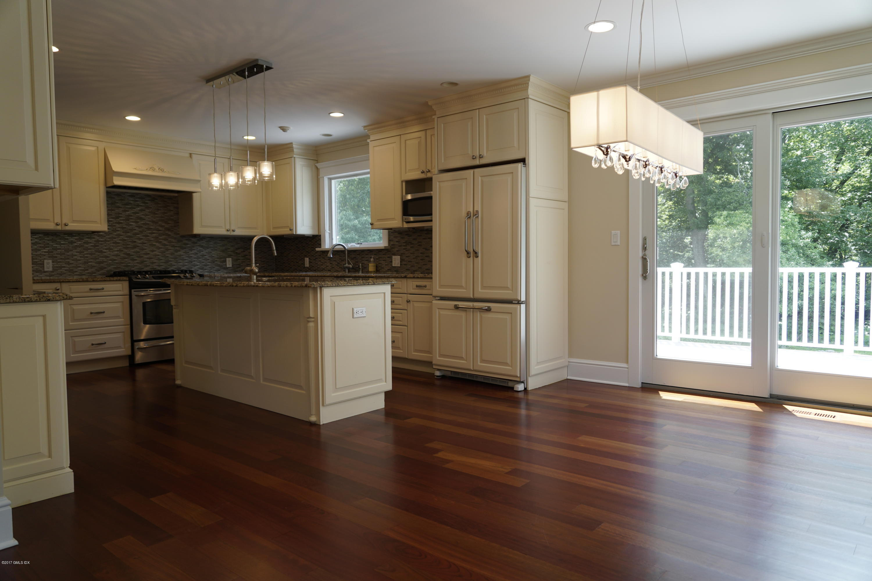 12 Birdsong Place Riverside, CT 06878 - Photo 5 of 30 a kitchen with kitchen island wooden floors white cabinets and stainless steel appliances