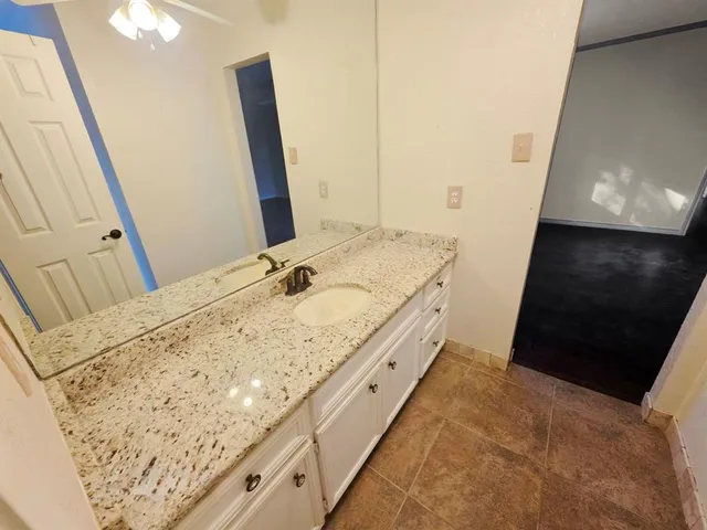 a bathroom with a granite countertop sink and a mirror