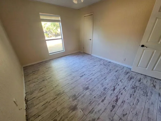 an empty room with wooden floor and window