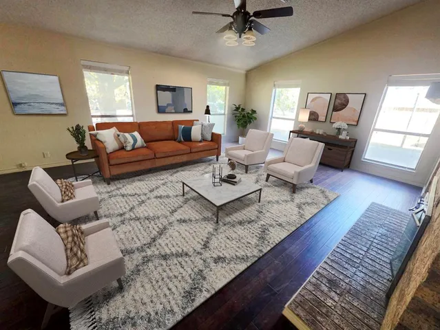 a living room with furniture and a wooden floor