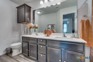 a bathroom with a granite countertop sink a toilet and a mirror