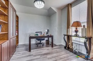 a view of a workspace with furniture and a window