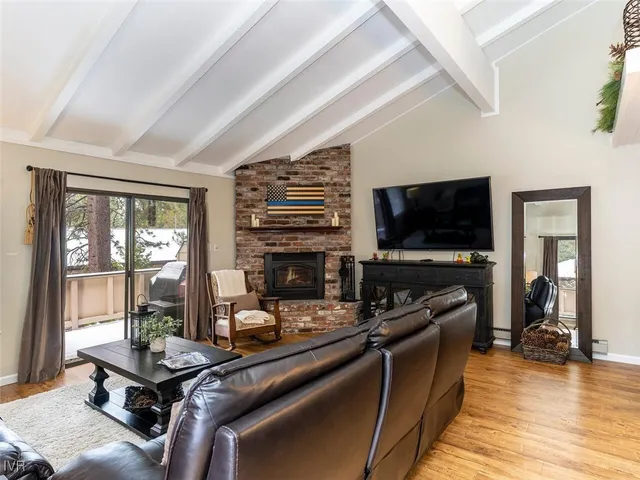 a living room with furniture a flat screen tv and a floor to ceiling window