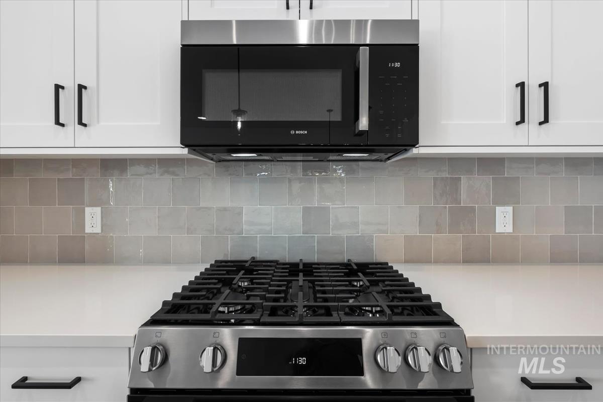 768 South Calhoun Lane Star, ID 83669 - Photo 15 of 36 Stainless steel gas range with a coordinating over-the-range microwave, set against a tile backsplash