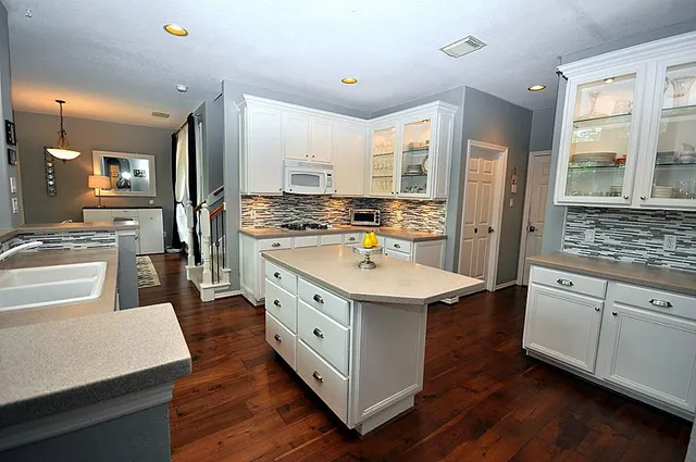 a large kitchen with stainless steel appliances a stove and a refrigerator
