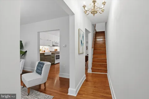 a view of a hallway with wooden floor and a dining room view