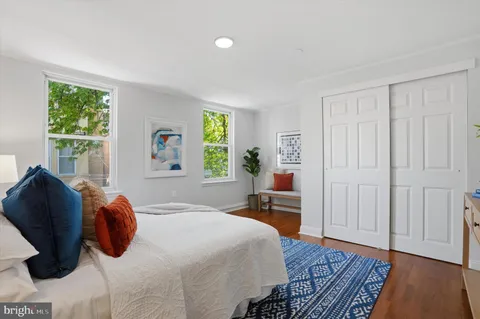 a bedroom with a bed and wooden floor