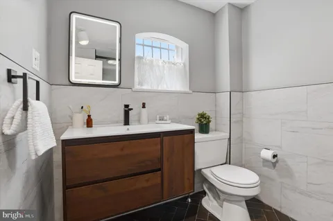 a bathroom with a sink a toilet and mirror