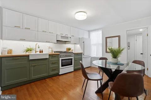 a kitchen with cabinets table and chairs