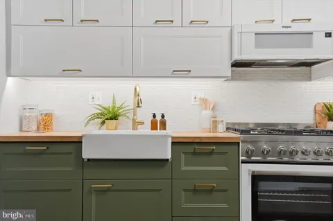 a white kitchen with a sink and cabinets