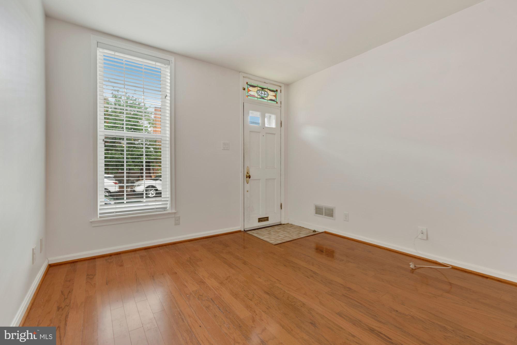 1445 Andre Street Baltimore, MD 21230 - Photo 2 of 22 a view of an empty room with wooden floor and a window
