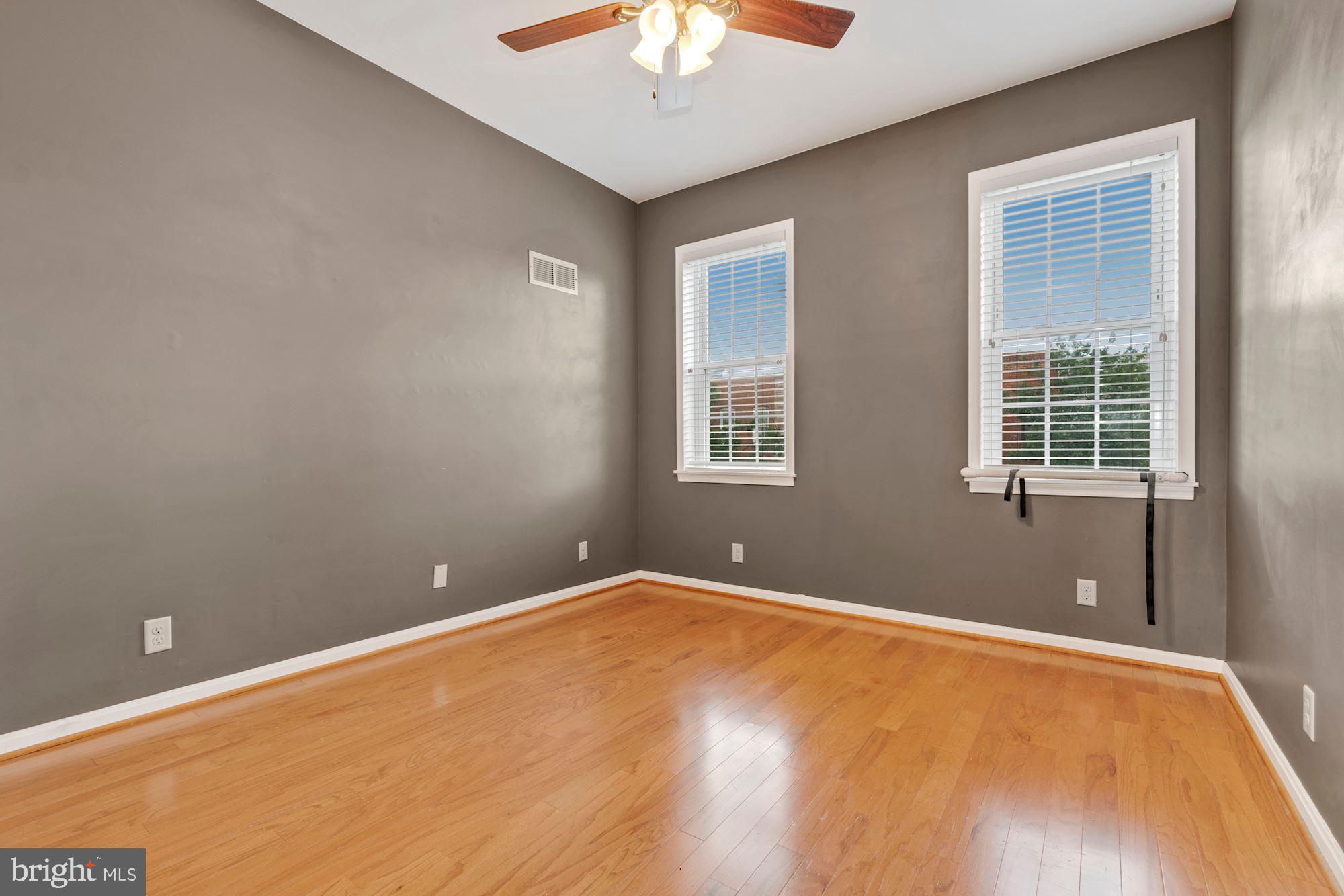 1445 Andre Street Baltimore, MD 21230 - Photo 11 of 22 an empty room with a chandelier fan and windows