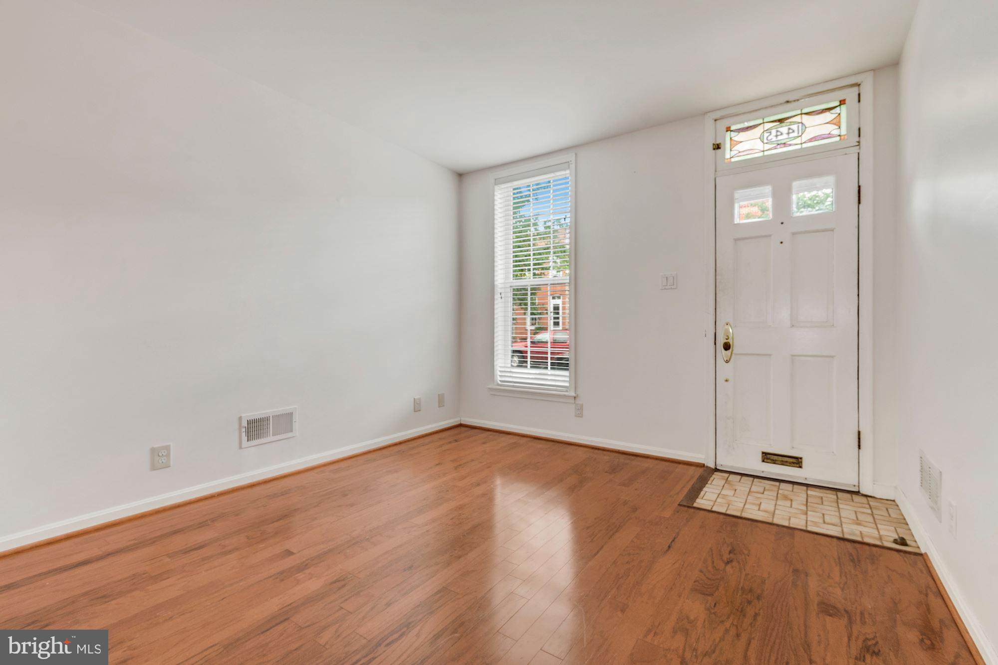 1445 Andre Street Baltimore, MD 21230 - Photo 3 of 22 an empty room with wooden floor and windows