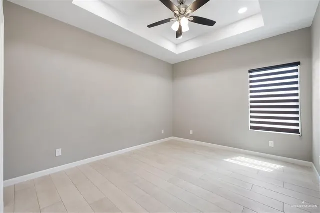 an empty room with a window and a fan