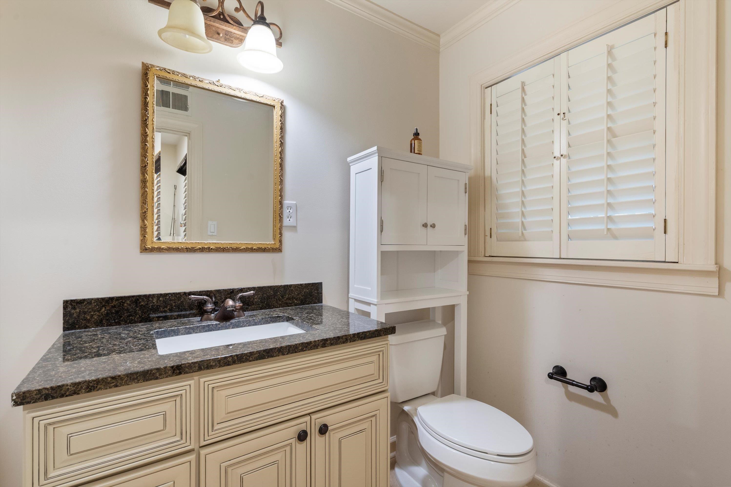 839 Reddoch Street Memphis, TN 38119 - Photo 31 of 36 a bathroom with a granite countertop toilet a sink and mirror