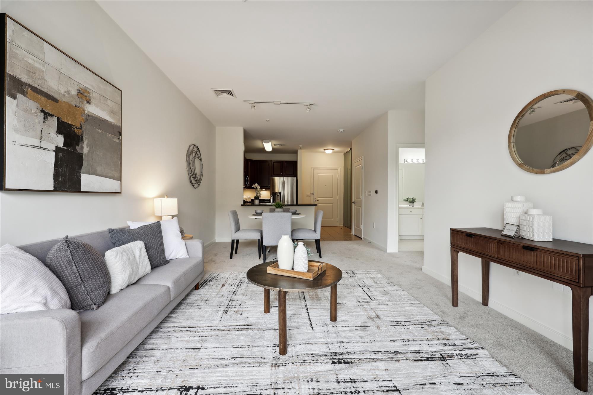 8045 Newell Street, Unit 319 Silver Spring, MD 20910 - Photo 26 of 66 a living room with furniture a rug and a chandelier
