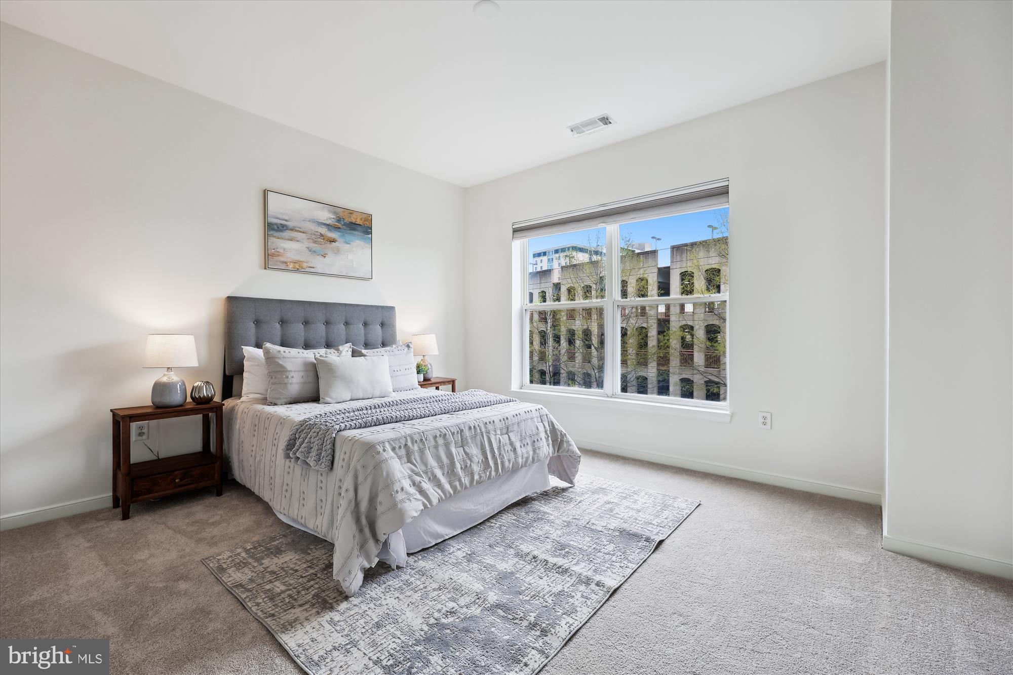 8045 Newell Street, Unit 319 Silver Spring, MD 20910 - Photo 28 of 66 a bed sitting in a spacious bedroom next to a window