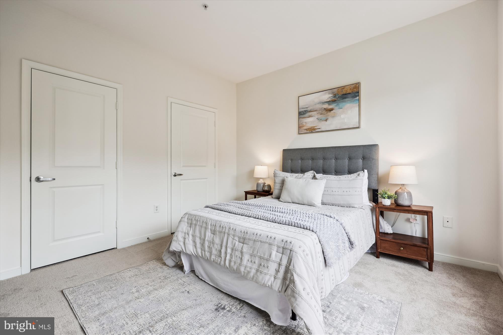 8045 Newell Street, Unit 319 Silver Spring, MD 20910 - Photo 30 of 66 a bedroom with a bed and a night stand