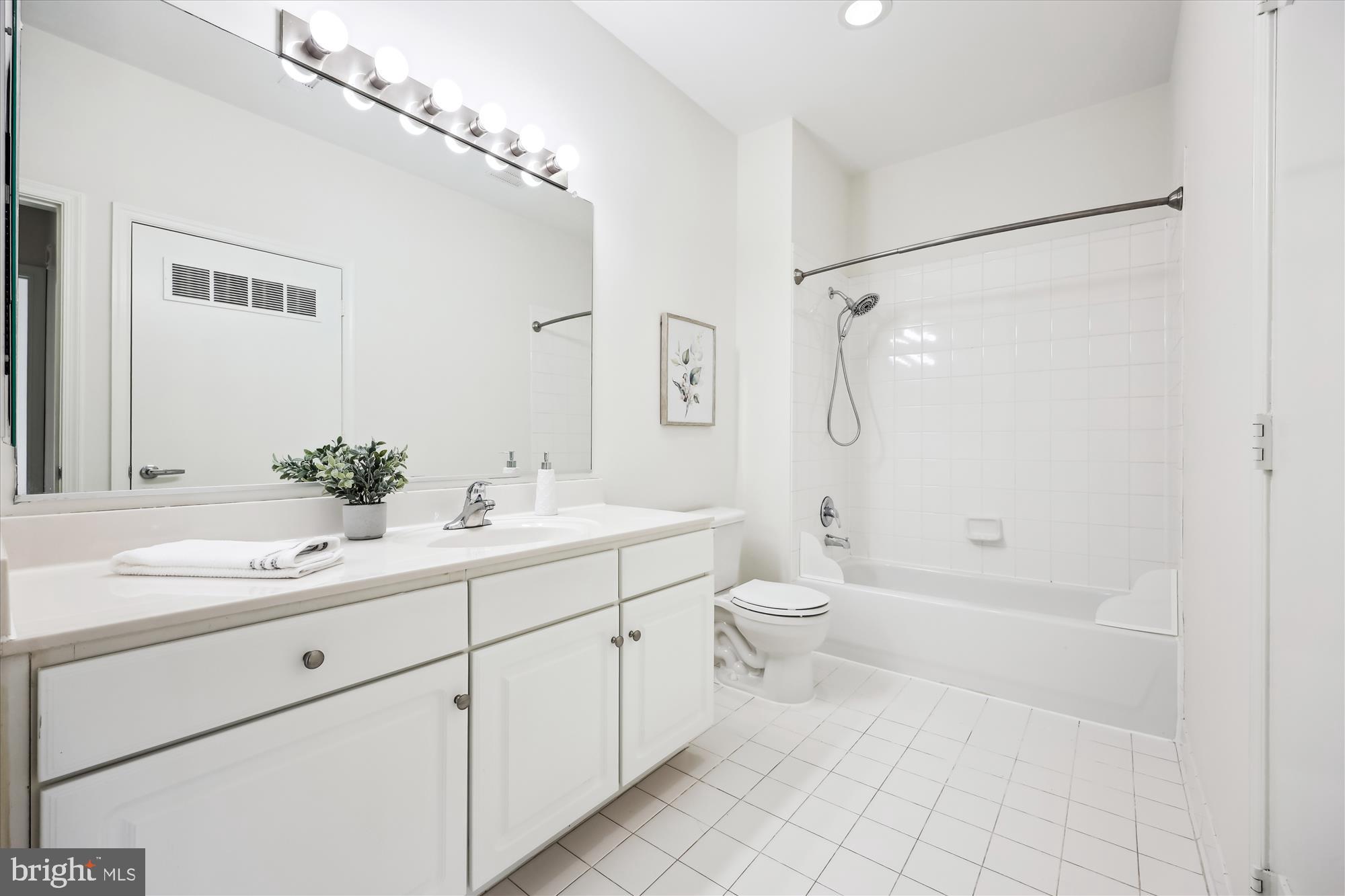 8045 Newell Street, Unit 319 Silver Spring, MD 20910 - Photo 33 of 66 a bathroom with a double vanity sink toilet mirror and shower