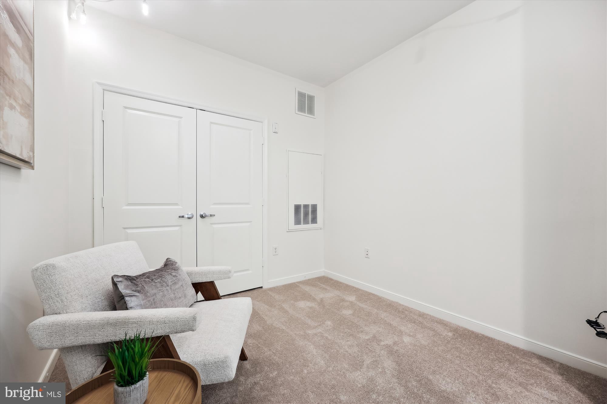 8045 Newell Street, Unit 319 Silver Spring, MD 20910 - Photo 5 of 66 a living room with furniture and a potted plant