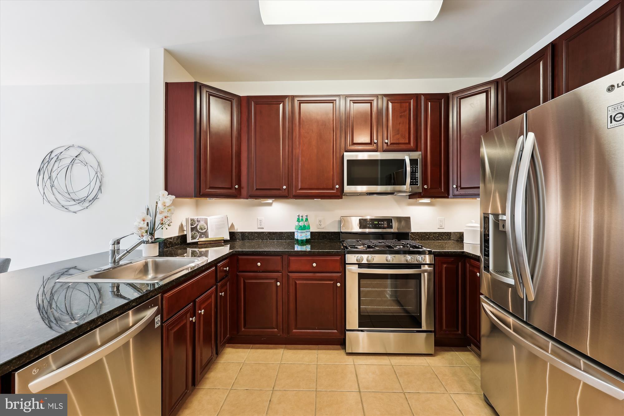 8045 Newell Street, Unit 319 Silver Spring, MD 20910 - Photo 10 of 66 a kitchen with stainless steel appliances granite countertop a stove top oven a refrigerator and a sink