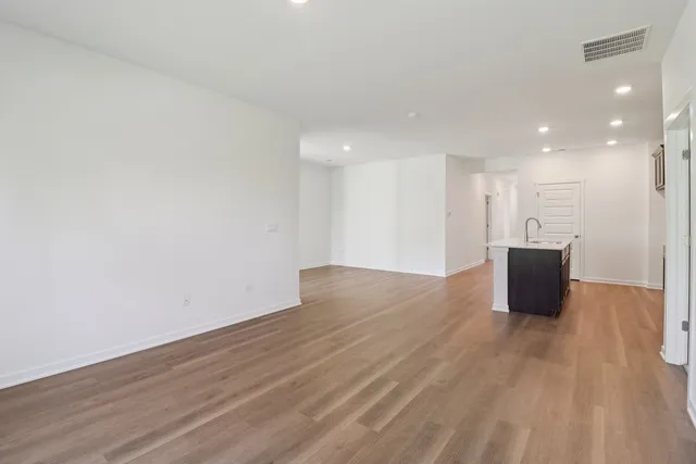 a view of a big room with wooden floor and windows