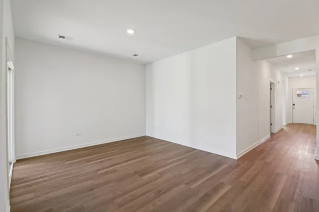a view of an empty room with wooden floor
