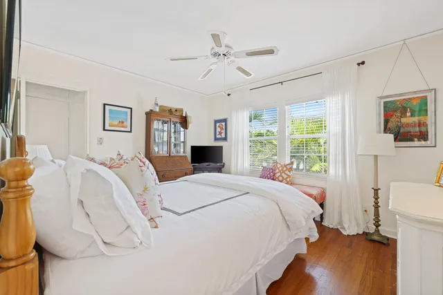 a sidewalk with a building and trees in the background