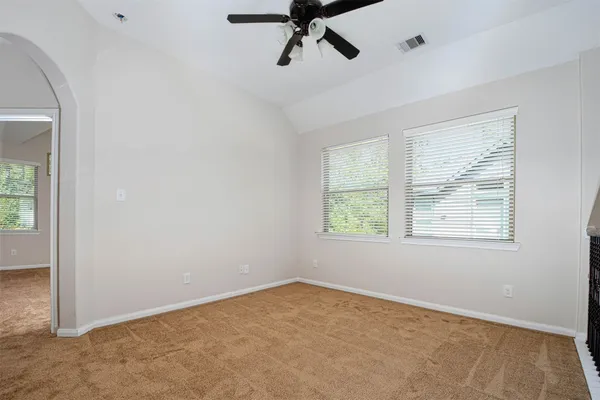 an empty room with a window and a ceiling fan