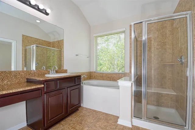 a bathroom with a granite countertop sink a mirror and a shower