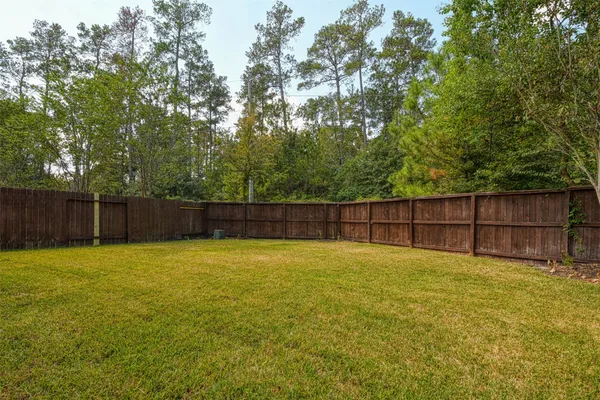 a view of a yard with wooden fence