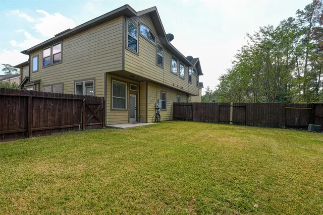 a view of a house with backyard and wooden fence