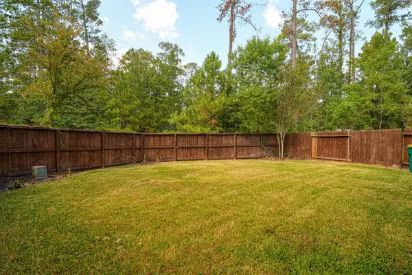 a view of a yard with wooden fence